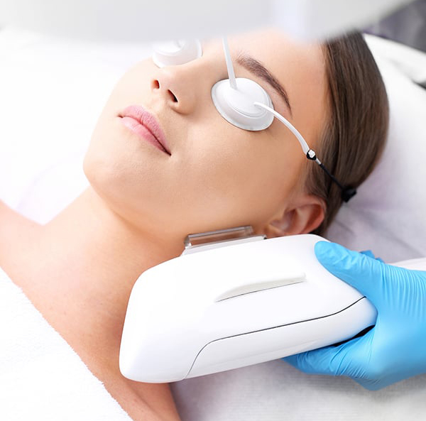 Laser technician applying laser skin therapy to a patient's face.