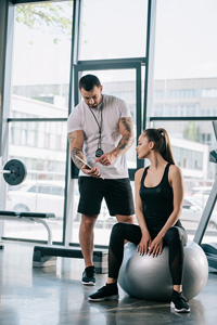 Personal trainer and client working at the gym